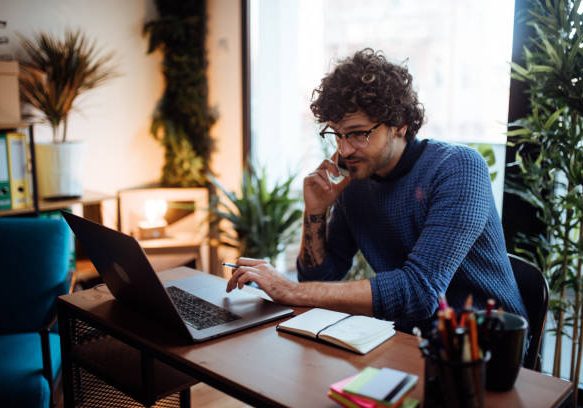 Young man talking on the phone in his home office